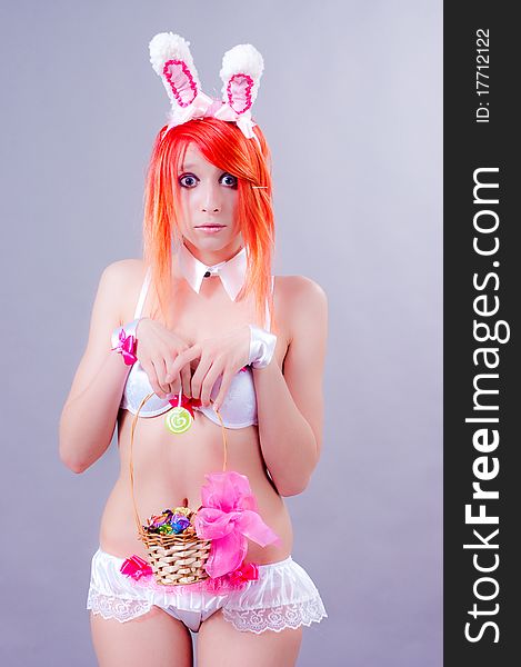 Woman easter bunny on gray background with orange hair. Woman easter bunny on gray background with orange hair