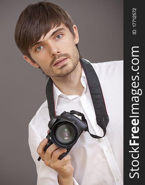 Male photographer with camera over grey background