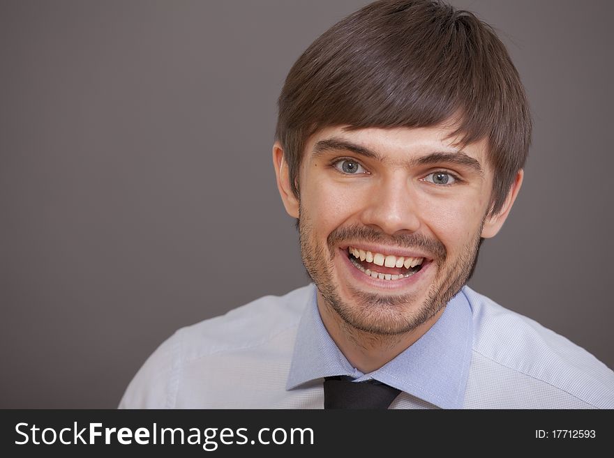 Happy and laughing man over grey background