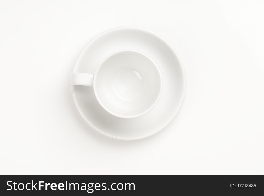Cup and plate prepared for drinking on a white background.