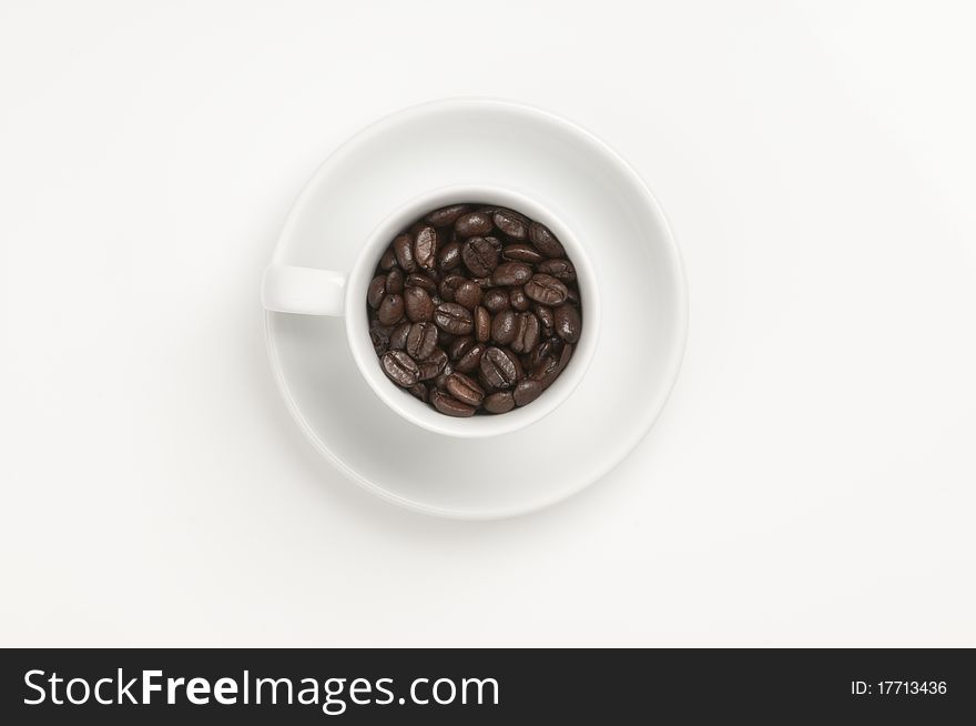 White coffee cup with plate and coffee beans. White coffee cup with plate and coffee beans.