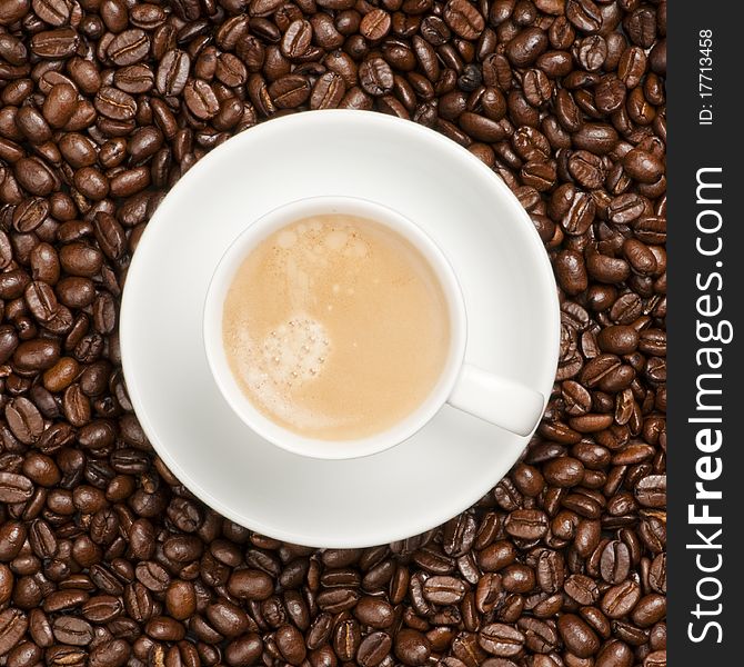 Cup and plate prepared for drinking on a coffee bean background. Cup and plate prepared for drinking on a coffee bean background.