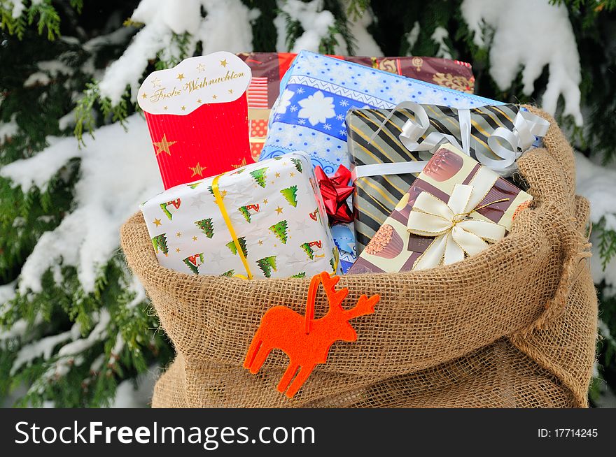 Bag of Christmas presents in the snow.