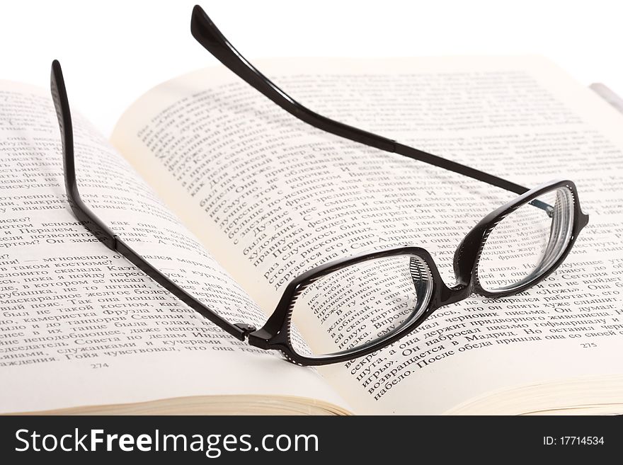 Close-up of spectacles lying on the opened book