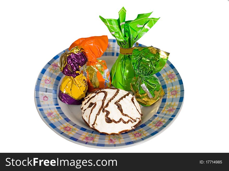 Four candy and a marshmallow on a small plate. white background. Four candy and a marshmallow on a small plate. white background