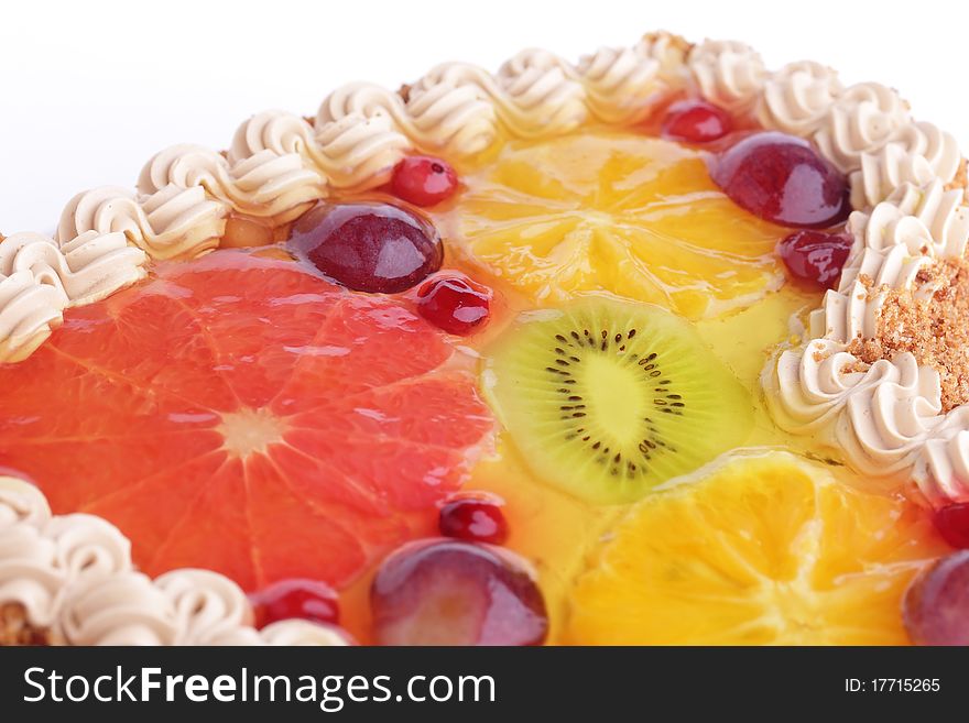 Delicious cake with whipped cream garnished with fruits (kiwi, grapefruit, orange, plum) in jelly isolated on white background. Delicious cake with whipped cream garnished with fruits (kiwi, grapefruit, orange, plum) in jelly isolated on white background