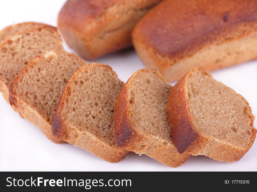 Fresh baked homemade loafs of rye bread and slices of cut rye bread isolated on white background. Fresh baked homemade loafs of rye bread and slices of cut rye bread isolated on white background