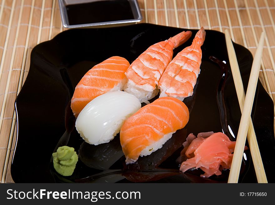Tasty dish of assorted sushi on black plate. Tasty dish of assorted sushi on black plate