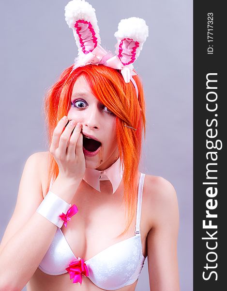 Woman easter bunny on gray background with orange hair. Woman easter bunny on gray background with orange hair