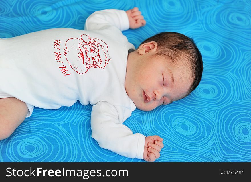 Baby girl of 21 days old sleeping on blue background. Baby girl of 21 days old sleeping on blue background