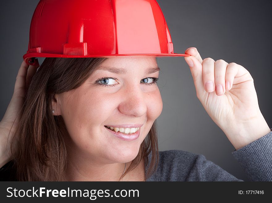 Portrait of young architect wearing red hardhat, looking at camera and smiling. Portrait of young architect wearing red hardhat, looking at camera and smiling