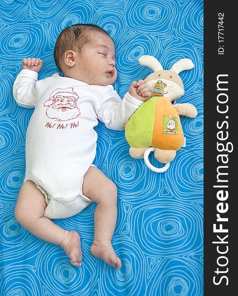 Baby girl of 21 days old sleeping on blue background. Baby girl of 21 days old sleeping on blue background