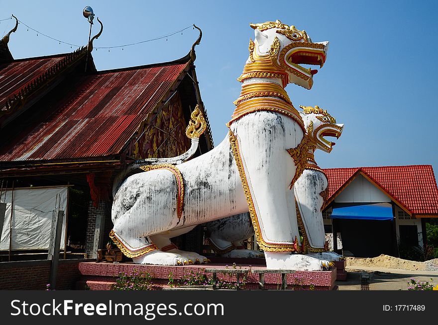 Antique guardian lion sculpture in front of the temple, thailand