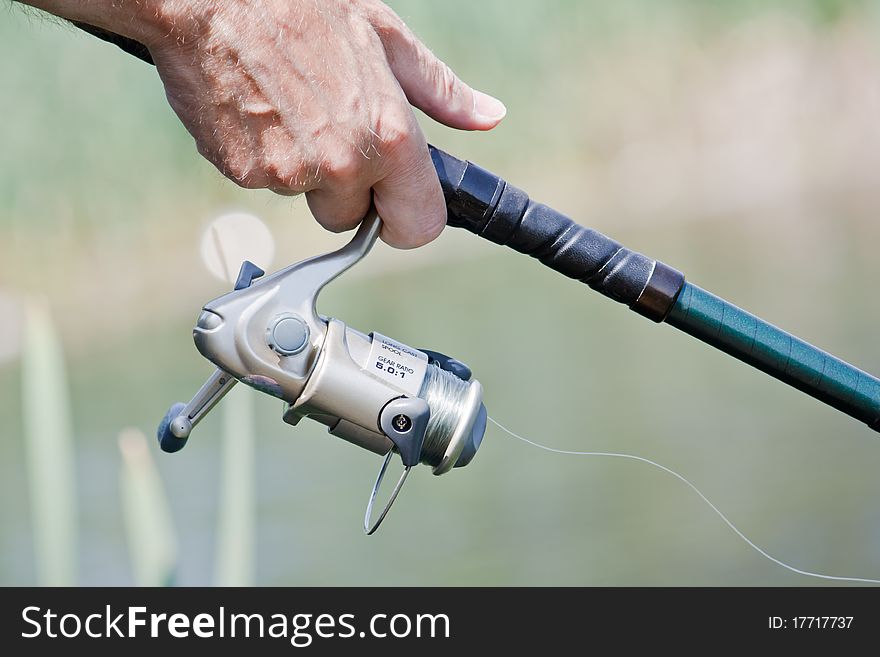 Closeup of a fisherman hand holding a fishing rod