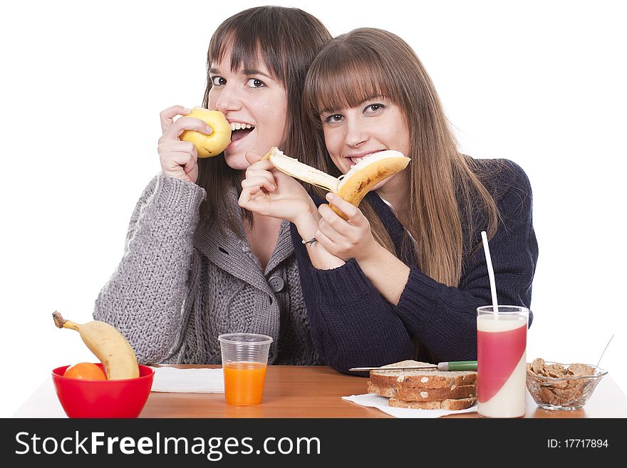 Two beautiful women eating breakfast