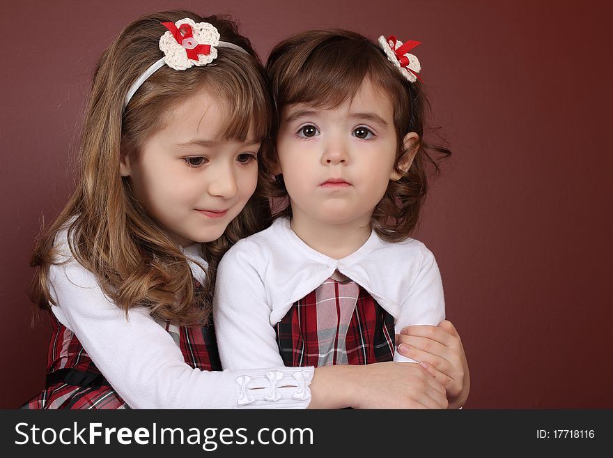 Two cute little sisters wearing Christmas dresses. Two cute little sisters wearing Christmas dresses