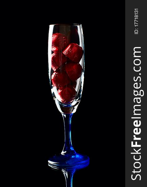 Wine glass with sweets inside. Black background. Studio shot. Wine glass with sweets inside. Black background. Studio shot.
