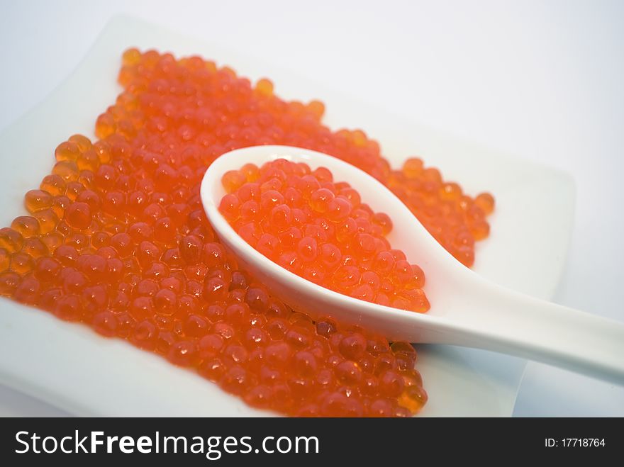 red caviar in a spoon, salmon caviar, it is isolated on white