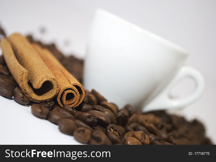 Cinnamon sticks near a coffee cup of white colour. Cinnamon sticks near a coffee cup of white colour