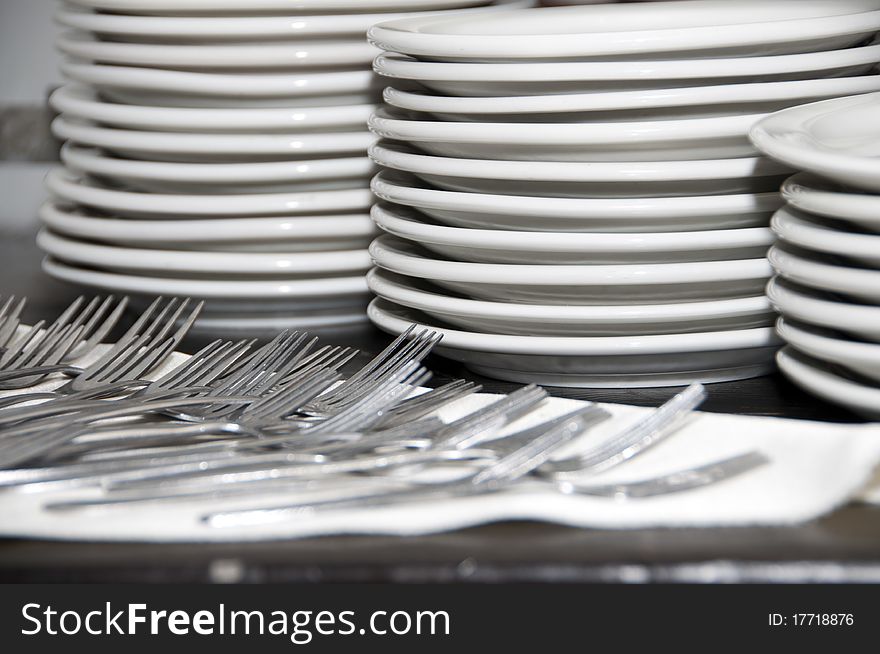 Plates forks on the table before distribution. Plates forks on the table before distribution