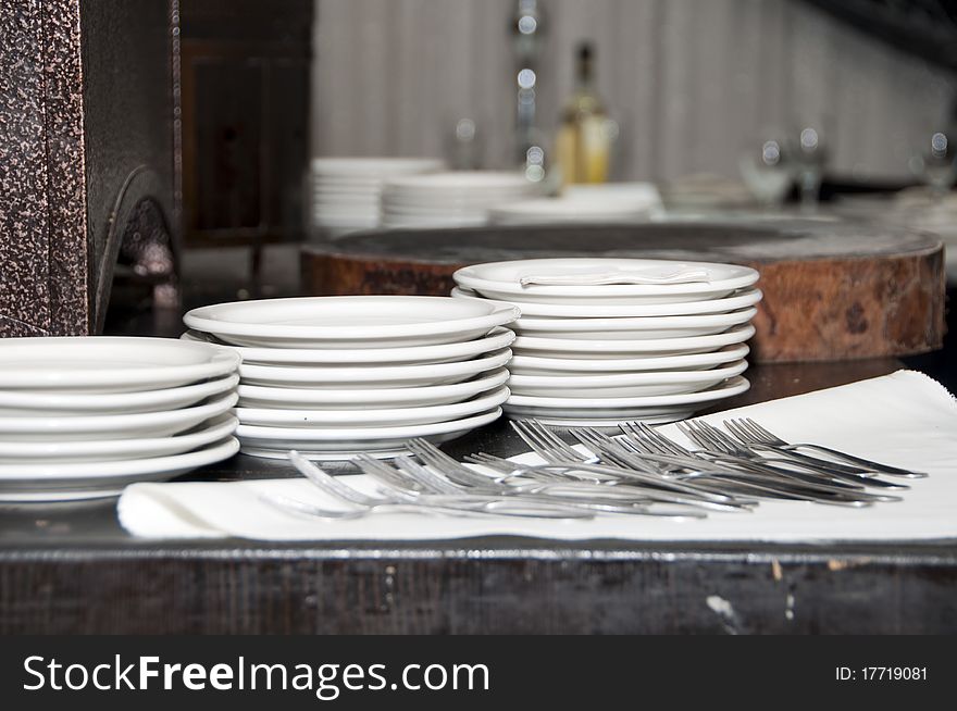 Plates forks on the table before distribution. Plates forks on the table before distribution