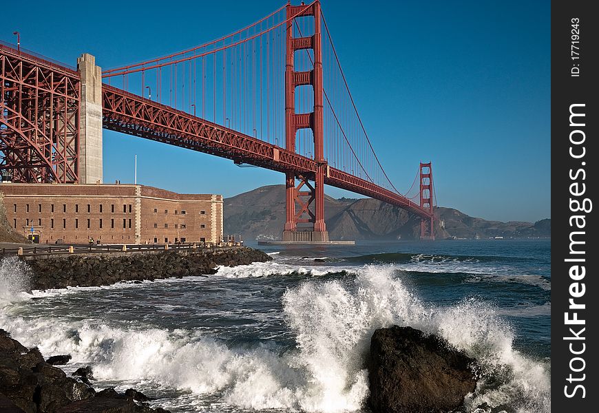 Golden Gate Bridge with large wave crashing.