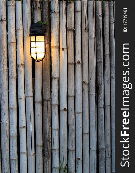 Yellow lamp on the bamboo fence in front of the resort in Thailand