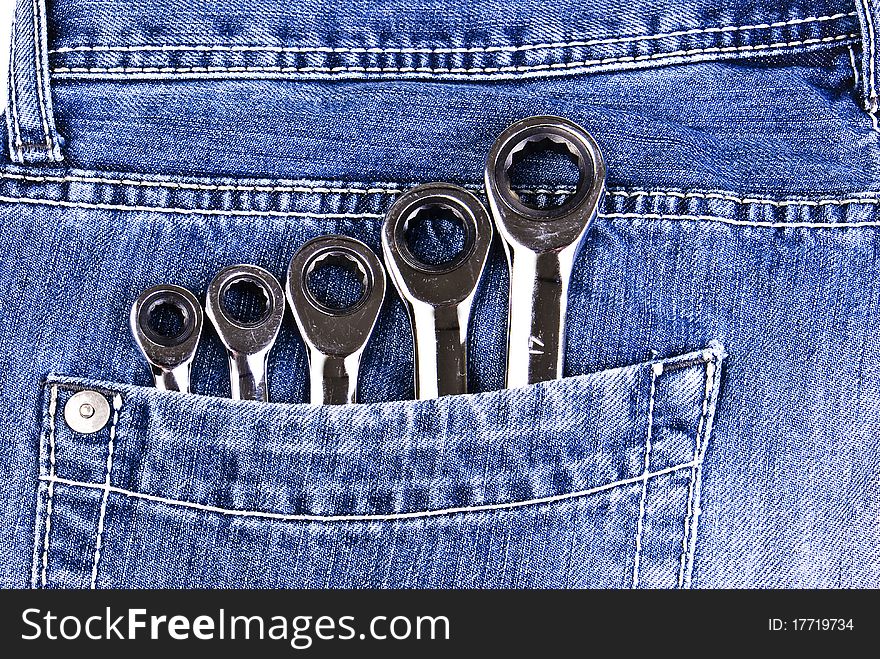 Five wrenches in a blue jeans pocket. Five wrenches in a blue jeans pocket