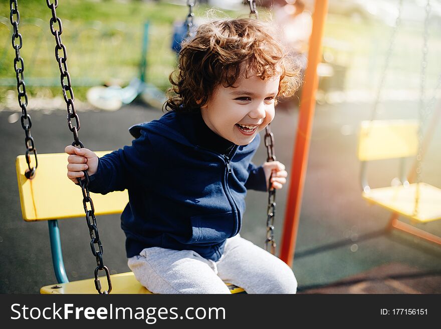 Funny Cute Happy Baby Playing On The Playground. The Emotion Of Happiness, Fun, Joy. Smile Of A Child.