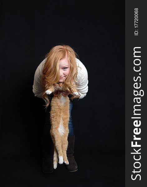 Red haired woman holding pet cat with same hair color. Red haired woman holding pet cat with same hair color