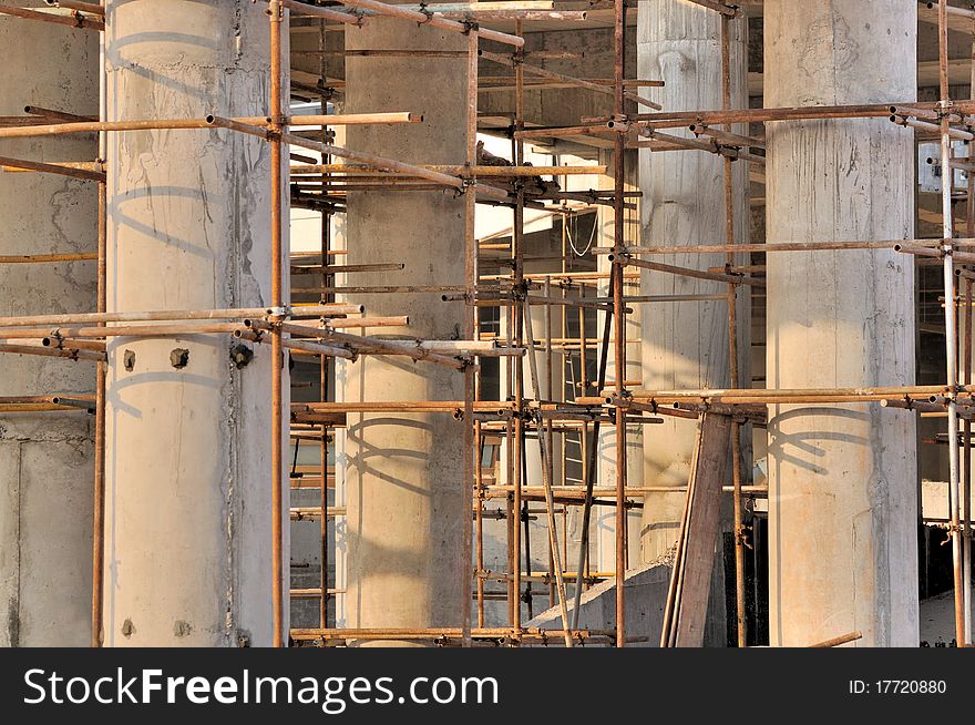 Scaffold and unfinshed poles in depth view, in big construction working area. Scaffold and unfinshed poles in depth view, in big construction working area.