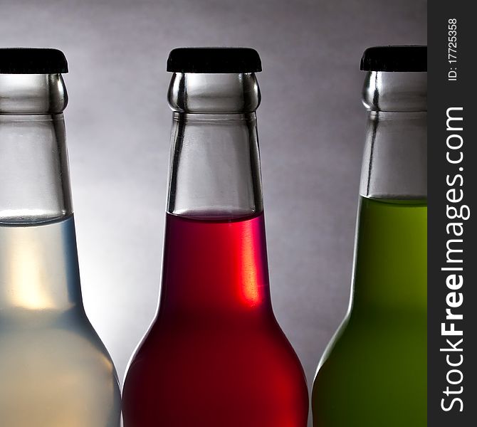 Three colorful bottle of drink on light background