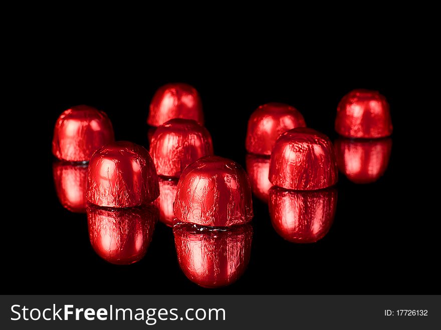 Set of sweets on redlection surface. Black background. Studio shot. Set of sweets on redlection surface. Black background. Studio shot.