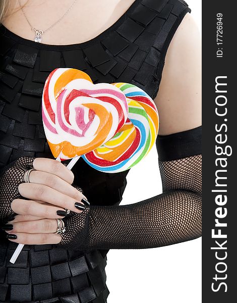 The young girl in black dress is holding a lollypops. The young girl in black dress is holding a lollypops