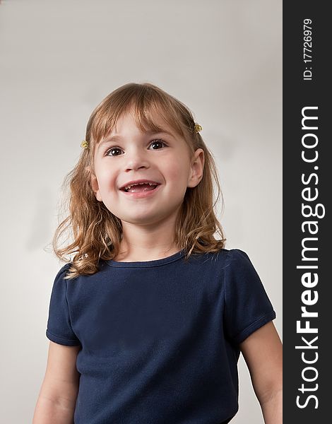 Portrait of pretty, smiling, little girl on plain background. Portrait of pretty, smiling, little girl on plain background.