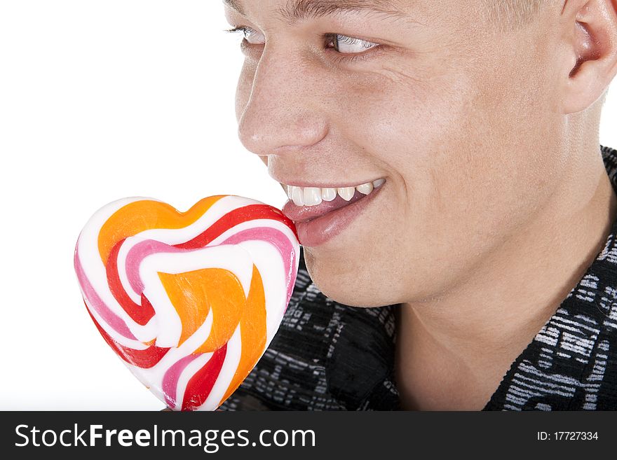 The young man is licking a lollypop