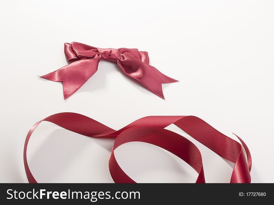 Bow and tape of darkly red colour on a white background.