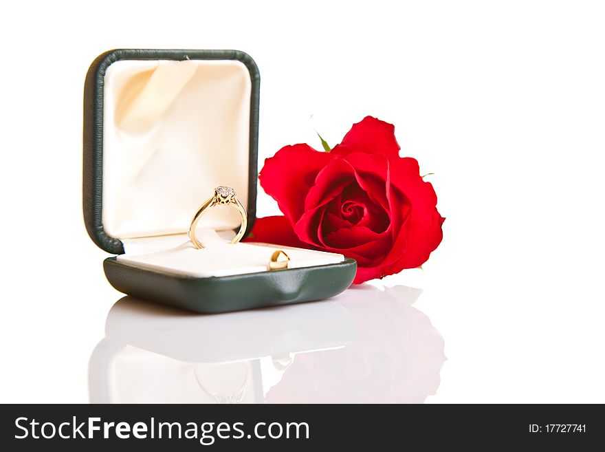Valentine's day engagement ring and red roses isolated on white