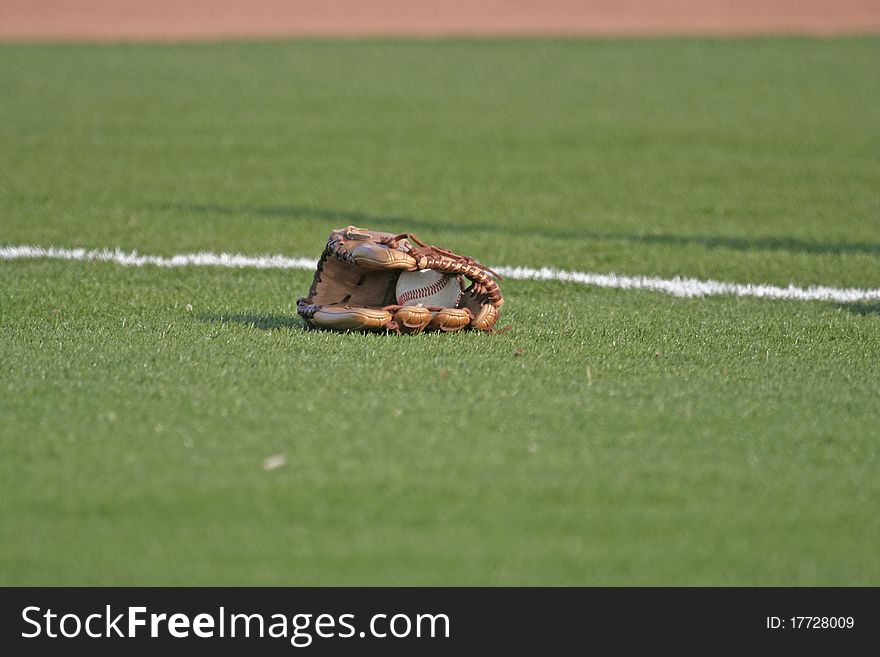 Baseball glove with baseball on the sport field