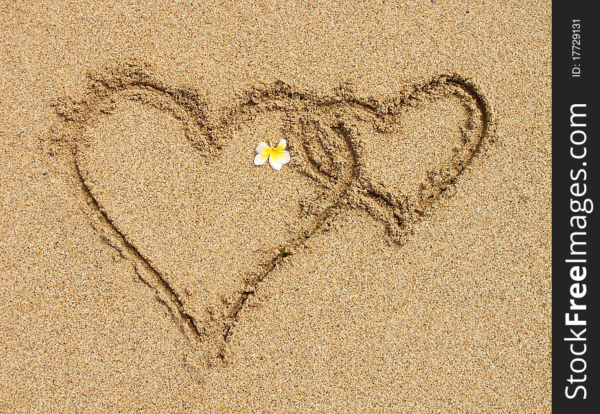 Two connected hearts drawn on wet sand. Two connected hearts drawn on wet sand