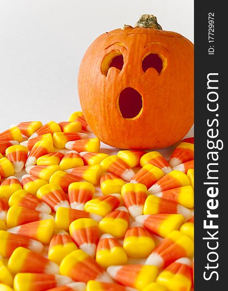 Jack-o-lantern with surprised expression as he finds himself surrounded with candy corn. Jack-o-lantern with surprised expression as he finds himself surrounded with candy corn