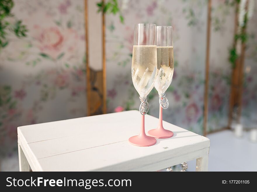Glasses with champagne on the table for the bride and groom at the engagement ceremony. Glasses with champagne on the table for the bride and groom at the engagement ceremony