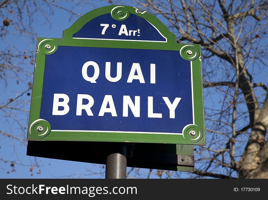 Quai Branly Street Sign, Paris with winter trees in background