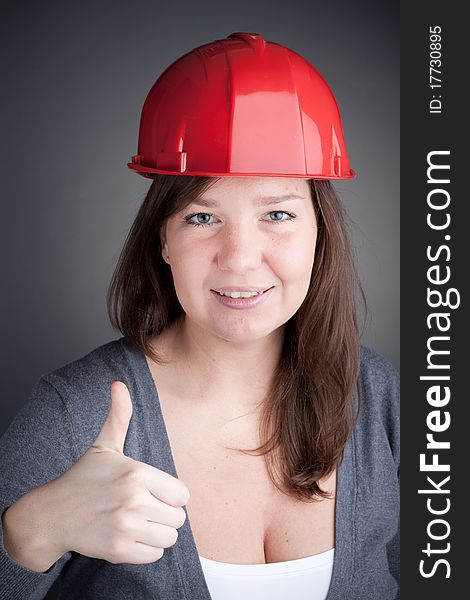 Young Engineer Woman With Thumb Up, wearing red safety hat