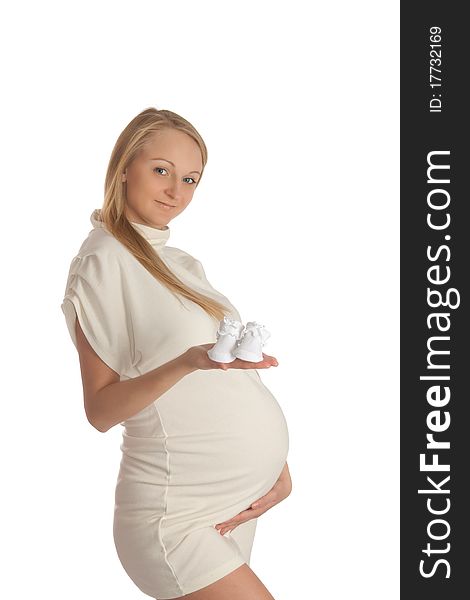 Pregnant young woman, holding baby's bootees. Pregnant young woman, holding baby's bootees.