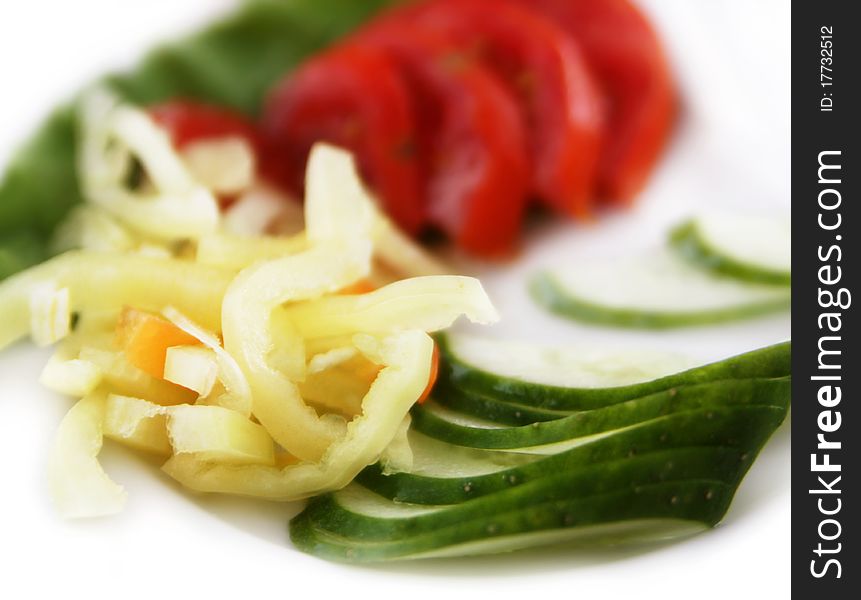 Vegetable mix of chopped peppers, cucumbers and tomatoes on a plate. Vegetable mix of chopped peppers, cucumbers and tomatoes on a plate