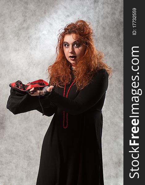 Crazy young woman with tousled hair and an empty bag in his hands