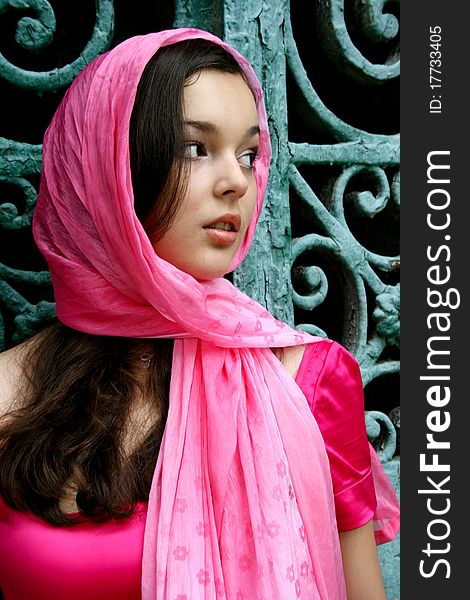 Young caucasian woman in pink near the gates. Young caucasian woman in pink near the gates