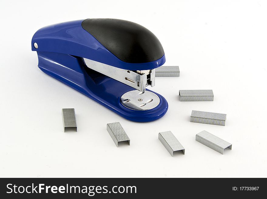 A blue stapler with paper clips on white background