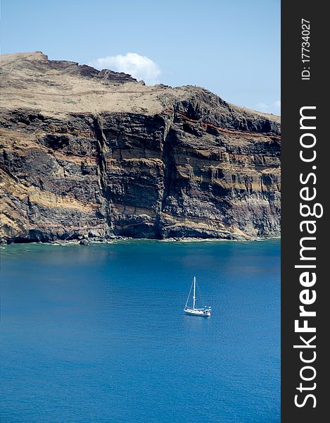 Sailboat anchored near cliff